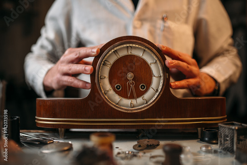 Watchmaker restore old wooden table clock