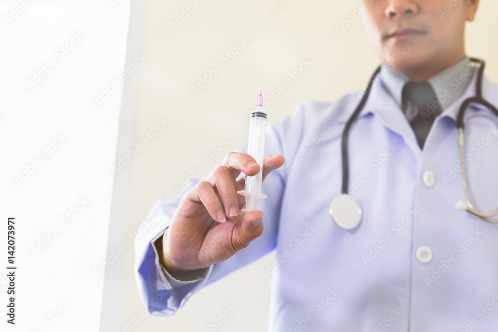 Doctor with syringe is preparing for medical injection, blur image for background Doctor with syringe is preparing for medical injection, blur image for background