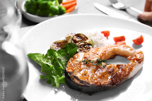 Grilled salmon steak with vegetables and rice on white plate
