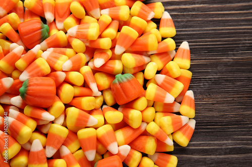 Tasty Halloween candies on wooden background, closeup