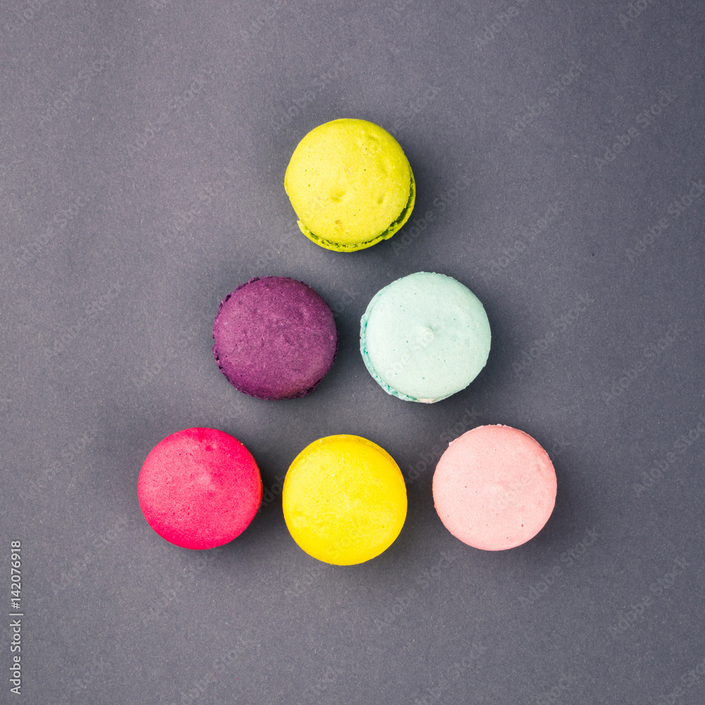 Colourful french macaroons on the grey background, Top view. Square Colourful french macaroons on the grey background, Top view. Square