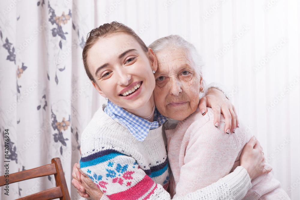 Helping hands, care for the elderly concept. Senior and caregiver holding hands at home