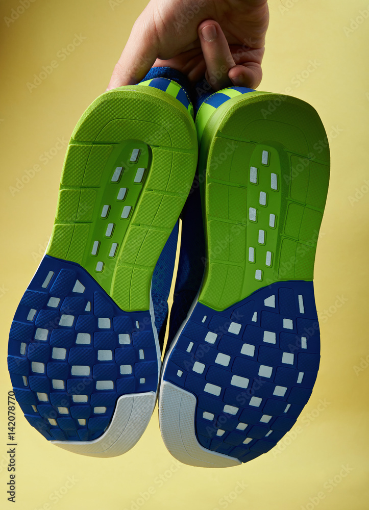 Hand holding running pair of shoes Hand holding running pair of shoes