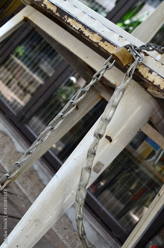 An iron chain with a lock twined around an old chair. select focus.Shot in a special angle. An iron chain with a lock twined around an old chair. select focus.Shot in a special angle.