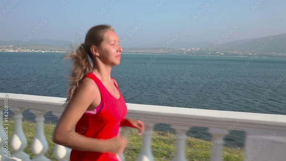 Young Fitness Woman Having An Exercise Run at sea coastline in the sunny morning