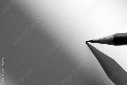 Pencil holding to write on the paper in shadow