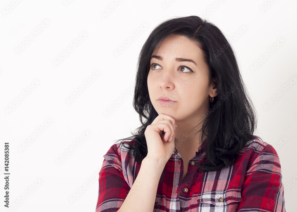 Young beautiful brunette hipster reflects on something. Looking thoughtfully aside and holding his chin with one hand. Studio shot on white background. Young beautiful brunette hipster reflects on something. Looking thoughtfully aside and holding his chin with one hand. Studio shot on white background.