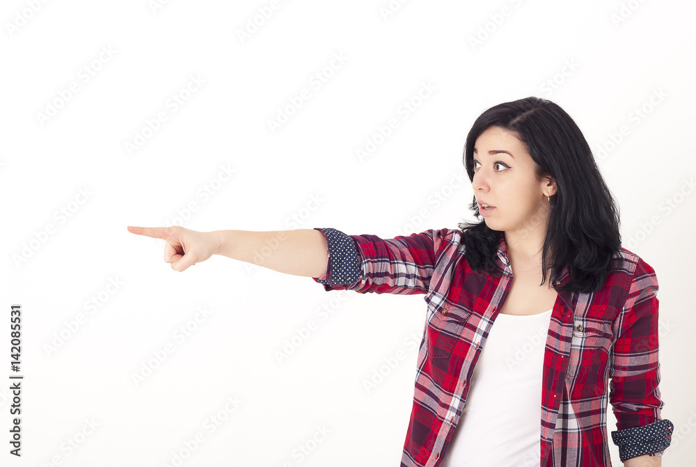 Shocked young girl shows her finger sideways, pointing at something interesting Shocked young girl shows her finger sideways, pointing at something interesting