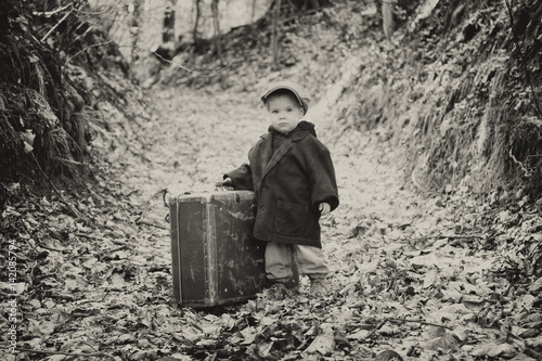 Lonely boy with suitcase, vintage