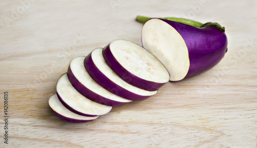 Raw violet eggplant on the wooden background.