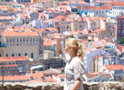 Tourist woman watching to Lisbon rooftop from viewpoint - Miradouro in Portugal