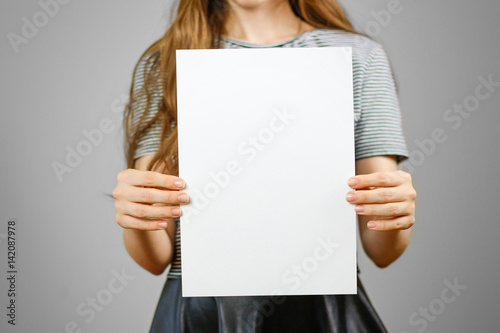 Woman showing blank white big A4 paper. Leaflet presentation. Pamphlet hold hands. Girl show clear offset paper. Sheet template. Booklet design sheet display read first person photo