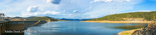 Beautiful panorama landscape of lake and dam surrounded by hills and mountains © Olga K