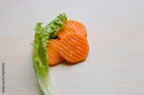 Sliced carrot with waves on a cutting board with fresh green salad