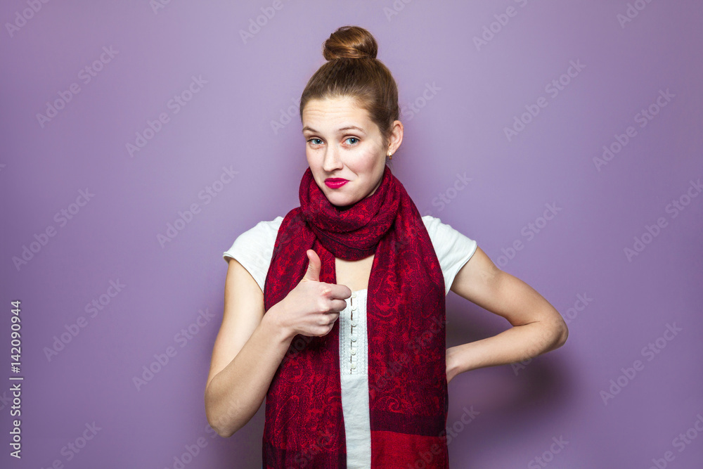 Thumbs up, young emotional girl with collected hair, freckles and red scarf  looking excited with thumbs