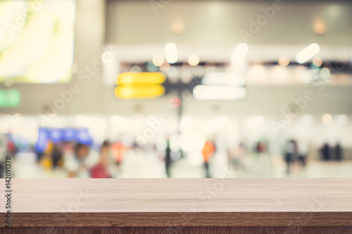 Empty wooden table for product placement or montage and blurred terminal department at airport background.
