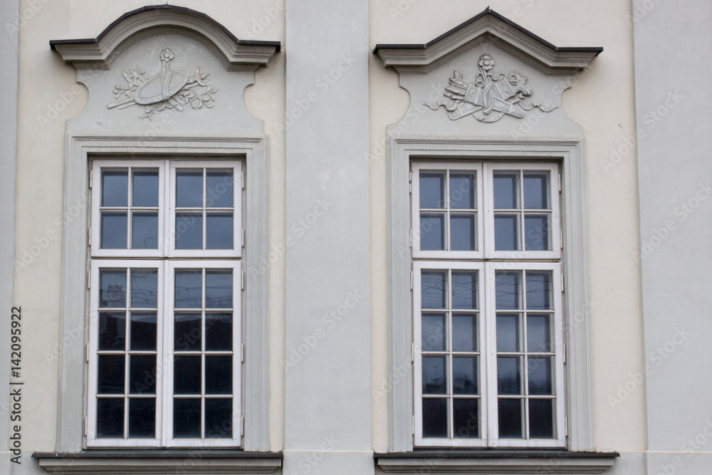 Two vintage design windows on the facade of the old house