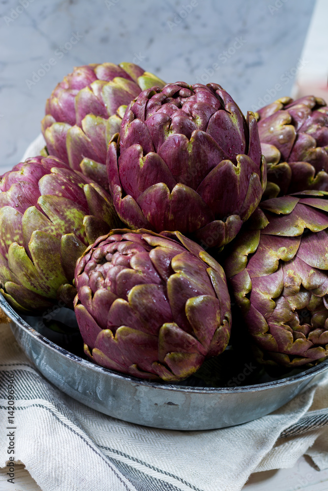 Fototapeta premium Fresh big Romanesco artichokes green-purple flower heads ready to cook