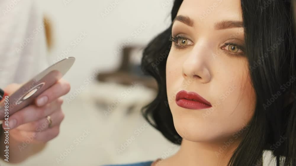 Make-up artist makes make-up young woman lips with lip pencil to stroke the lips Make-up artist makes make-up young woman lips with lip pencil to stroke the lips