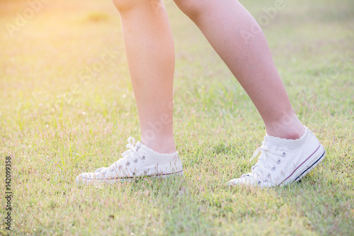 women walk on grass with sneakers
