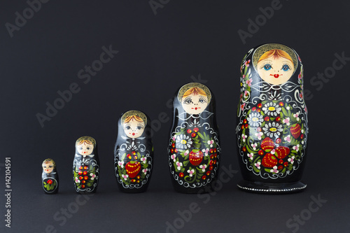 Fotografia Beautiful black matryoshka dolls with white, green and red painting in front of