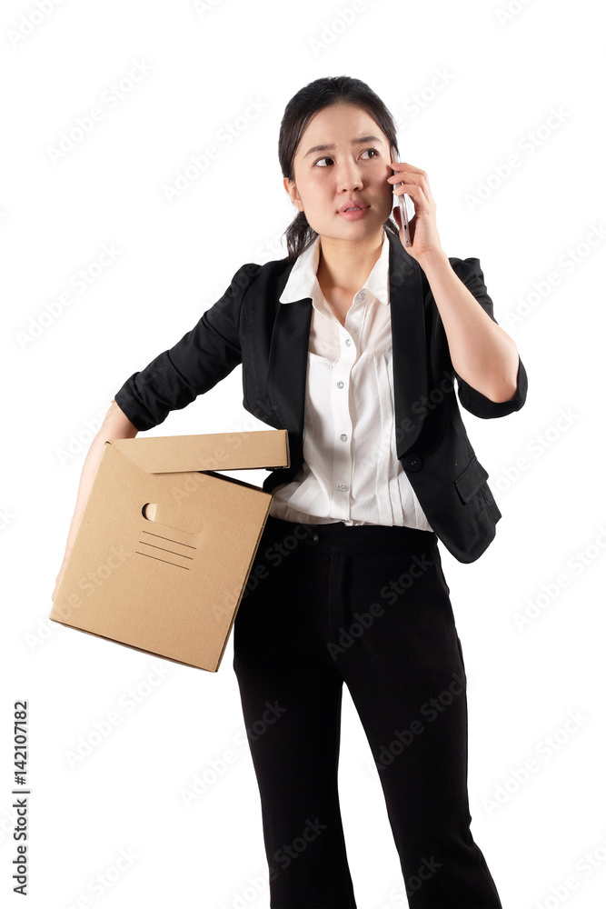 A young woman carrying a box and talking on the phone A young woman carrying a box and talking on the phone