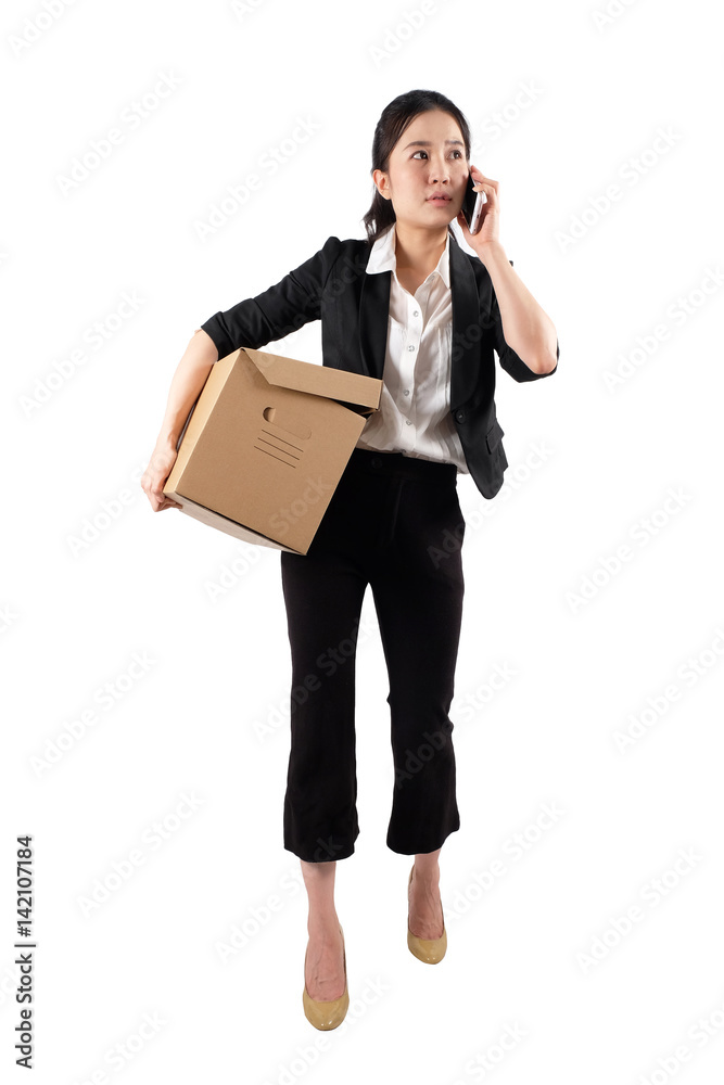 A young woman carrying a box and talking on the phone A young woman carrying a box and talking on the phone