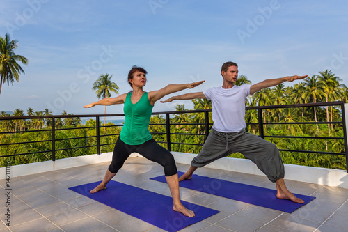 Yoga instructor conducts classes with the woman on the balcony of the hotel