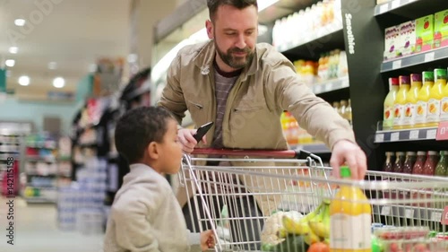 Father and son doing weekly shop in grocery store