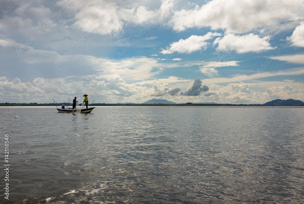 Two people fishing with net from a boat in Sarawak, Borneo