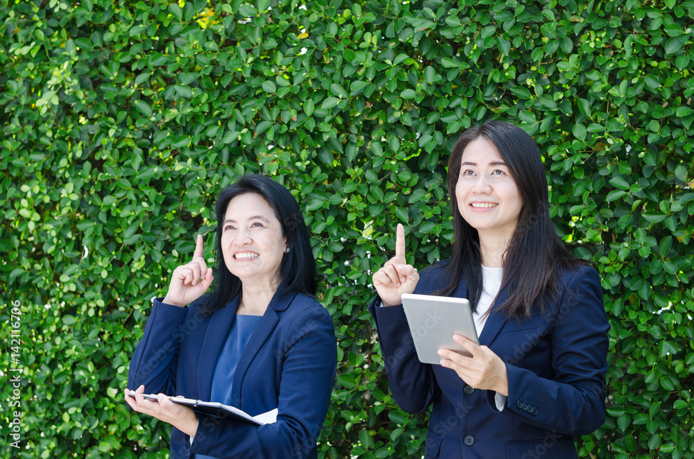 Two business women looking up and thinking about goals. Two business women looking up and thinking about goals.
