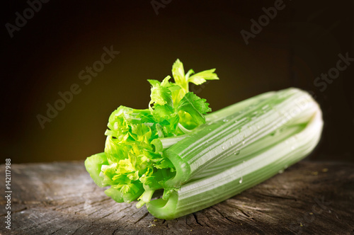 Celery closeup over black background. Leaves and stem of fresh organic green celery