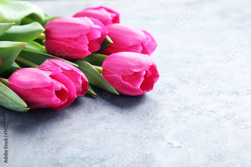 Bouquet of pink tulips on grey wooden table