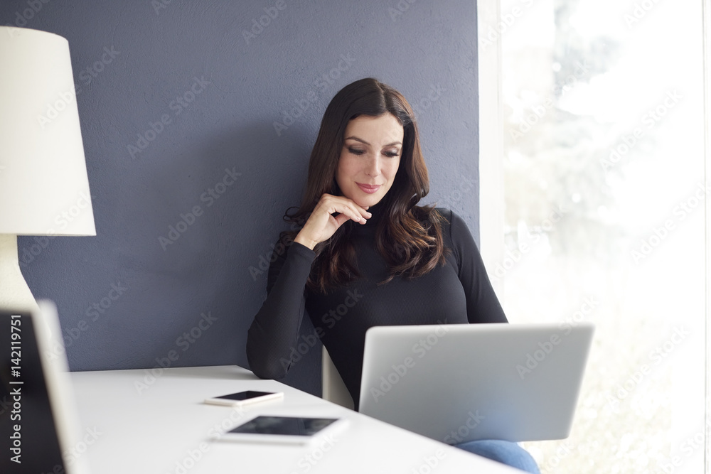 Thinking on new ideas. Shot of a young creative businesswoman working on laptop at office. Thinking on new ideas. Shot of a young creative businesswoman working on laptop at office.