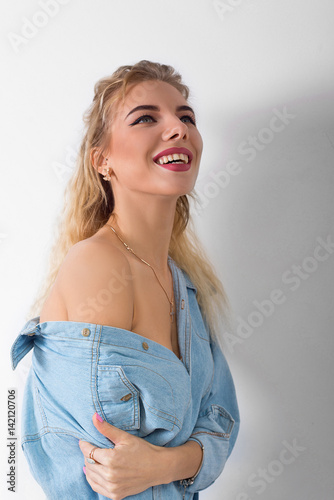 Beautiful girl in jeans and a shirt laughing smiling happy
