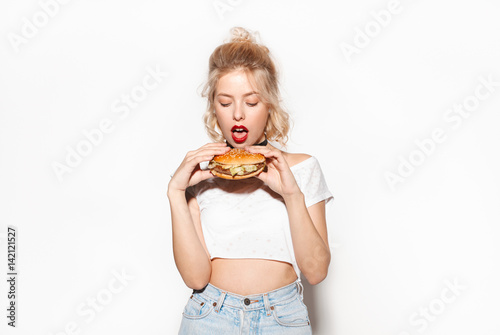 Young woman holding a big burger