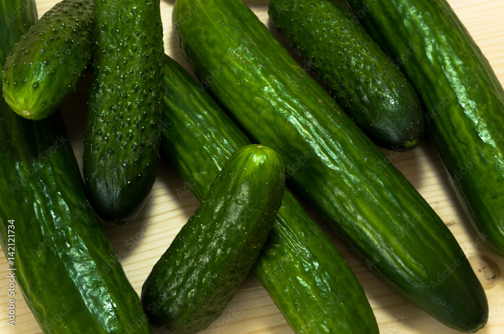 Green cucumbers on wooden table, top view Green cucumbers on wooden table, top view