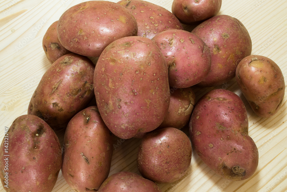Pile of raw potatoes on wooden table background. Pile of raw potatoes on wooden table background.