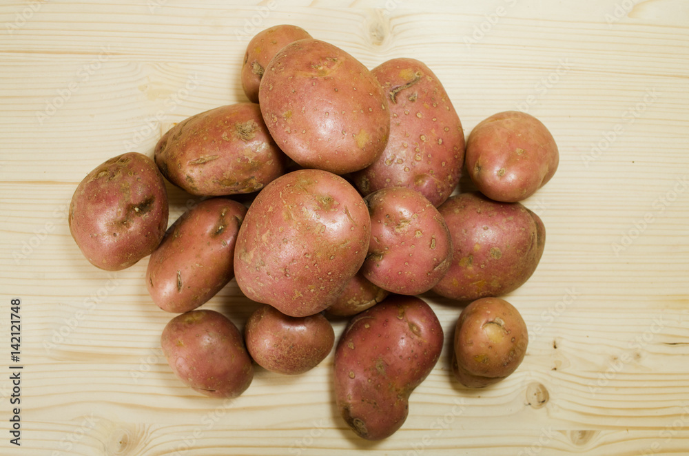 Pile of raw potatoes on wooden table background. Pile of raw potatoes on wooden table background.