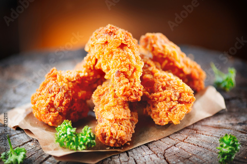 Photo Crispy fried kentucky chicken wings on wooden table