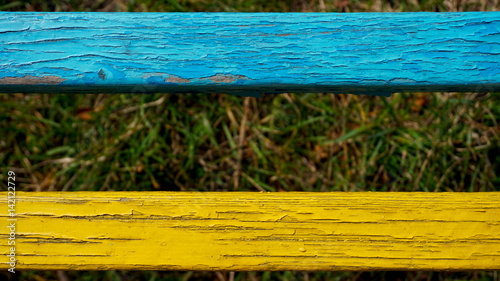 Two old wooden slats painted in blue and yellow.