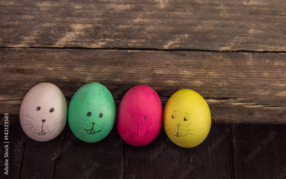 Easter eggs cute face on rustic wooden background Easter eggs cute face on rustic wooden background