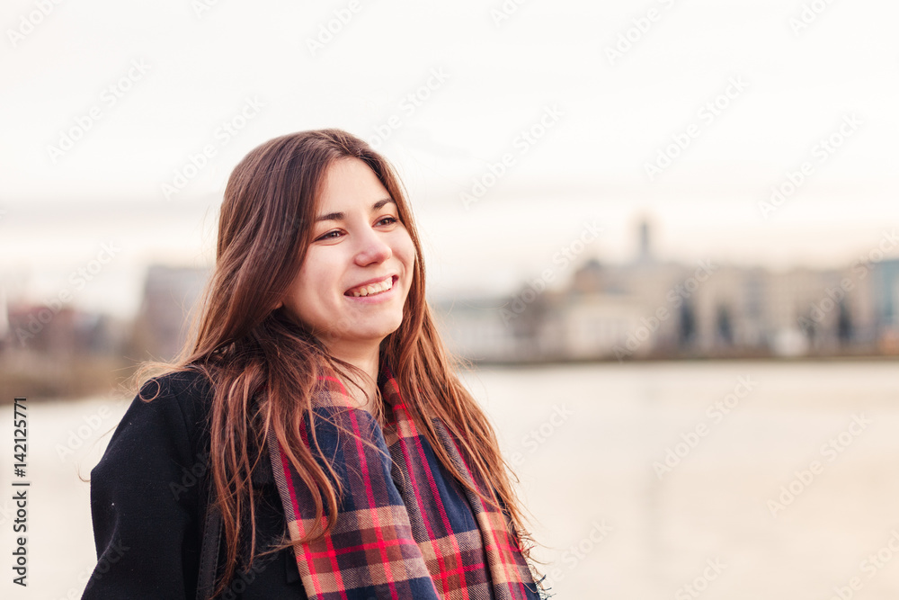 Young attractive girl in the city at sunset