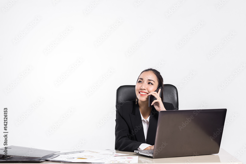 Beautiful business Asian woman smiling while talking on the smartphone at her office desk. Beautiful business Asian woman smiling while talking on the smartphone at her office desk.
