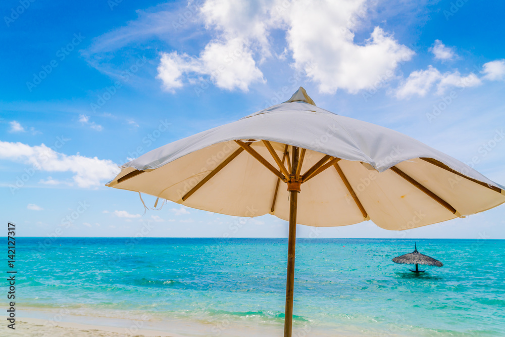 Beach chairs with umbrella at Maldives island, white sandy beach and sea .