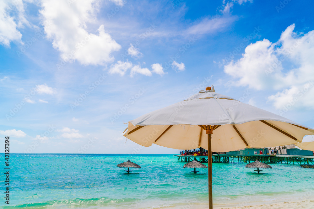 Beach chairs with umbrella at Maldives island, white sandy beach and sea .