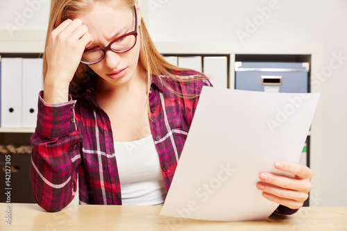 Frau mit Brief schaut besorgt photo