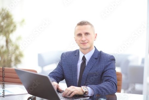 Young businessman working with laptop at modern office