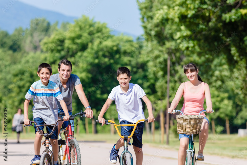 Fototapeta premium Family of four on bike tour in summer