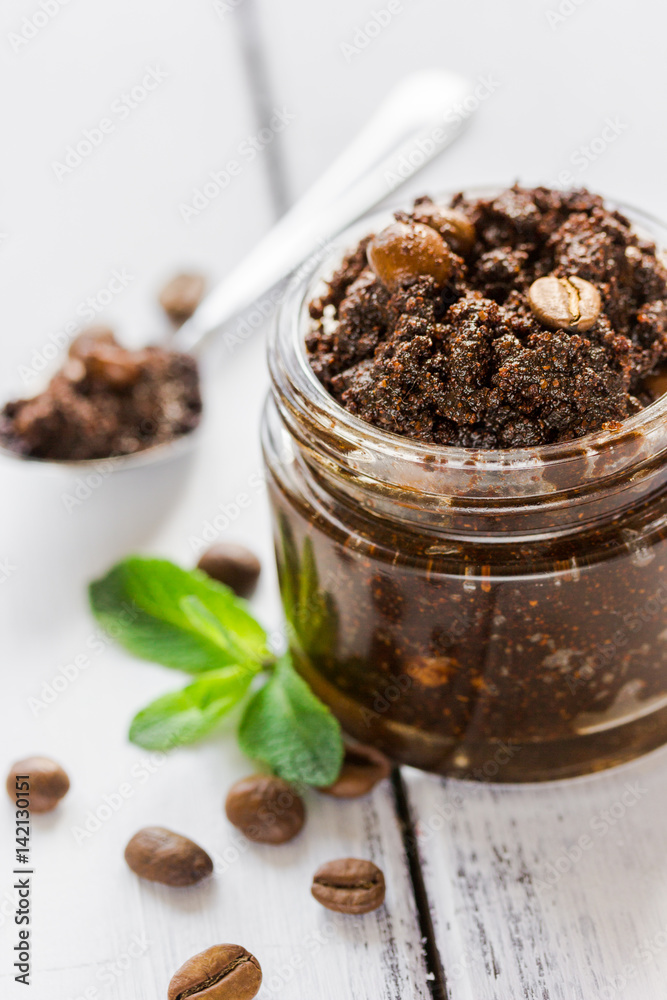 Homemade cosmetics with scrub and coffee beans on desk background Homemade cosmetics with scrub and coffee beans on desk background